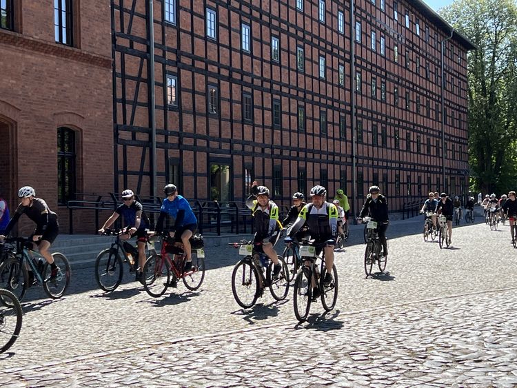 Grupa rowerzystów przed budynkiem Młynów Rothera w Bydgoszczy.